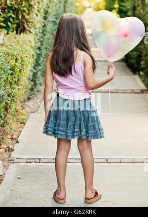 Rückansicht des Kind hält Form Herzballon Stockfoto