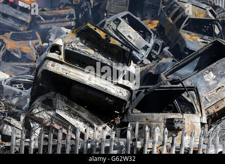 Ausgebrannte Autos auf einem Schrottplatz auf dem Randolf Industrial Estate in Kirkcaldy, Fife, wo mindestens 70 Feuerwehrleute einen großen Brand bekämpfen. Stockfoto