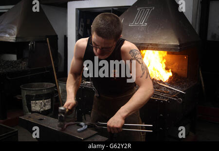 Der Lehrling Farrier Trooper Matthew Wade macht ein Hufeisen in der Hyde Park Barracks in London. Stockfoto