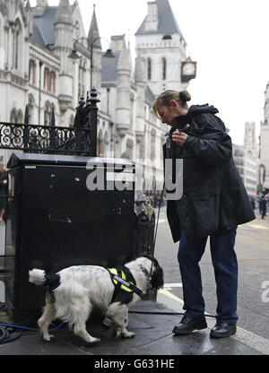 Ein britischer Polizist führt Sicherheitskontrollen mit einem schniffereren Hund vor der zeremoniellen Trauerprozession von Baroness Thatcher in der St. Paul's Cathedral im Zentrum von London durch. Stockfoto