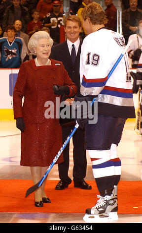 Die britische Königin Elizabeth II hält den Puck, als sie mit Marcus Naslund von den Vancouver Canucks spricht, bevor sie während ihrer zweiwöchigen Golden Jubilee Tour durch das Land ein Eishockeyspiel zwischen San Jose Sharks und Vancouver Canucks in Vancouver, Kanada, begann. *..früher gingen die Königin und ihr Mann, der Herzog von Edinburgh, zur Kirche in der Christ Church Cathedral in Victoria, gefolgt von einem Mittagessen im Fairmont Empress Hotel, wo das königliche Paar von den Pfeifen und Trommeln des kanadischen schottischen Regiments begrüßt wurde. Stockfoto