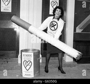 Die jüngere Gesundheitsministerin Edwina Currie zeigt, wie man das Rauchen abwürgen kann, als sie am National No Smoking Day im Londoner West End den ersten rauchfreien Wettladen Großbritanniens im Besitz von Ladbrokes eröffnet. Stockfoto