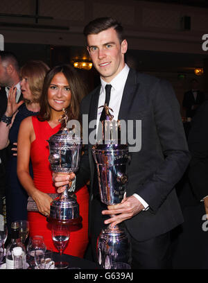 Gareth Bale von Tottenham Hotspur mit seiner Auszeichnung "PFA Player of the Year" und seinem "PFA Young Player of the Year Award" mit seiner Freundin Emma Rhys-Jones während der PFA Player of the Year Awards 2013 im Grosvenor House Hotel, London. Stockfoto