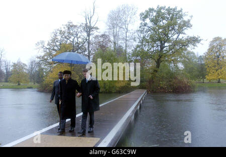 Der ehemalige südafrikanische Präsident Nelson Mandela (Mitte), Earl Spencer (rechts) und ein Adjutanten-Spaziergang über einen Ponton von der Insel, auf der Diana, Prinzessin von Wales, in ihrem Stammhaus in Althorp in Northamptonshire begraben liegt. * Mandela pflanzte einen Baum auf dem Gelände des Anwesens und legte einen Kranz auf der Beerdigungsstätte der Insel, während des Besuchs, um mit Dianas Bruder Earl Spencer ein neues Wohltätigkeitsprojekt zu besprechen. Stockfoto