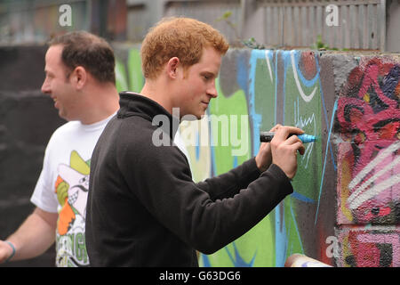 Prinz Harry signiert seinen Namen auf einer Graffiti-Wand während seines Besuchs im Russell Youth Club, Nottingham. Stockfoto