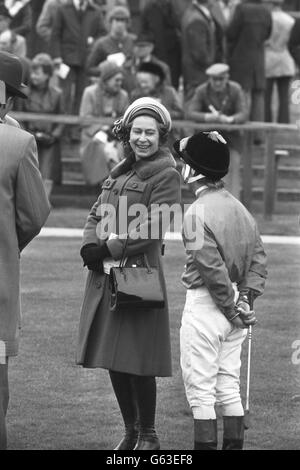 Die Königin teilt einen Witz mit Jockey Willie Carson im Fahrerlager, bevor er Sea Boat, einen hengst, den sie letztes Jahr kaufte, auf den dritten Platz im Ladbroke Racing Handicap bei Newmarket brachte. Stockfoto