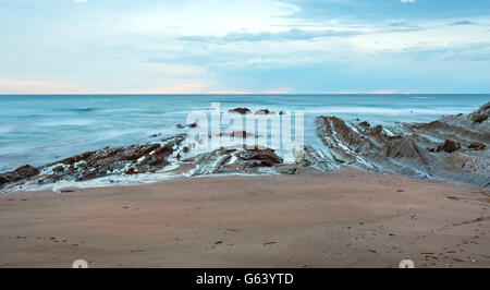 Dämmerung Ozeanküste mit gerippten stratiforme Felsformationen (Atlantik, Spanien). Stockfoto