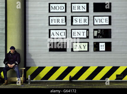 Am zweiten Tag des zweitägigen landesweiten Feuerwehrstreiks sitzt vor der Tollcross Fire Station in Edinburgh ein Feuerwehrmann. Stockfoto