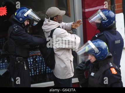 Metropolitan-Polizisten verhaften einen Verdächtigen während einer groß angelegten Drogenrazzia auf dem Gelände in Kensal Rise, im Norden Londons. Etwa 250 Beamte der Tactical Support Group, der Polizei von Brent Borough und der britischen Verkehrspolizei nahmen an der Razzia in drei Gebäuden Teil. * innerhalb von Minuten wurden fünf Verdächtige verhaftet. Die Polizei sagte, dass sie zwei Friseure und ein Restaurant anvisieren würden. Die Operation mit dem Codenamen Razor fand nach monatelangen Überwachungs- und Nachrichtendiensten statt. Stockfoto