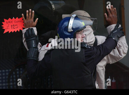 Ein Metropolitan-Polizeibeamter verhaftete einen Verdächtigen während eines groß angelegten Drogenraubens auf dem Gelände in Kensal Rise im Norden Londons. Etwa 250 Offiziere der Tactical Support Group, der Brent Borough Police und der British Transport Police nahmen an der Razzia in drei Räumen Teil. Innerhalb von Minuten waren fünf Verdächtige festgenommen worden. Die Polizei sagte, dass sie zwei Friseure und ein Restaurant anvisieren würden. Die Operation mit dem Codenamen Razor fand nach monatelanger Überwachung und nachrichtendienstlicher Sammlung statt. Stockfoto