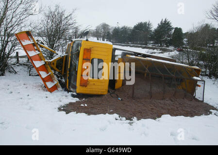 Ein Schneepflug liegt auf seiner Seite, nachdem er die Straße mit einer vollen Ladung Sand verlassen hat, auf dem Boden des Shanes Hill in der Grafschaft Antrim.Autofahrer auf beiden Seiten der irischen Grenze standen vor Verkehrschaos, als Winterschneeszards weiterhin Straßen in starkem Schnee und Eis bedeckten. *..die Polizei in Nordirland und der Irischen Republik forderte die Menschen auf, mit äußerster Vorsicht zu fahren, da Straßen, die über Nacht geschlossen worden waren, nach und nach wieder geöffnet wurden. Stockfoto