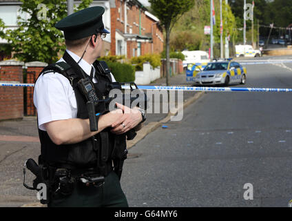 Bewaffnete Polizisten verschließen ein Gebiet im Norden Belfasts nach einem Doppelpfeifenbombenanschlag auf die Polizei. Stockfoto