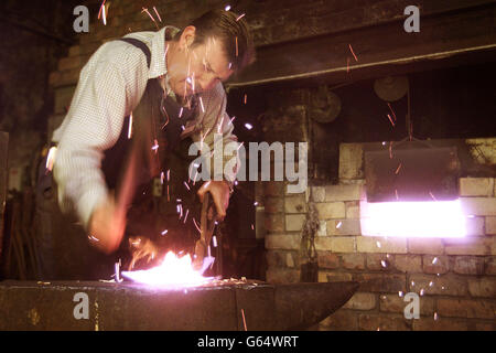 Spademaker Colin Dawson bei der Arbeit in Pattersons Spatenmühle in Templepatrick, Co Antrim. Die Mühle wurde kurz nach dem Ersten Weltkrieg begonnen und erreichte ihren Höhepunkt in den 1940er Jahren, als sie mehr als ein Dutzend Männer beschäftigte. * Lieferung von Pik, Schaufeln und loys (lange, schmale Pik, mit einer Fußstütze auf einer Seite des Griffes) in ganz Irland und darüber hinaus. Die Herstellung eines Spaten in Pattersons war und ist ein gut ausgebildeter Betrieb, und die Arbeiter in der Fabrik verfügen über ein enzyklopädisches Wissen über Irlands 171 anerkannte Designs von Spaten und die Fähigkeiten, die von Vater zu Sohn weitergegeben wurden. Die Mühle war Stockfoto