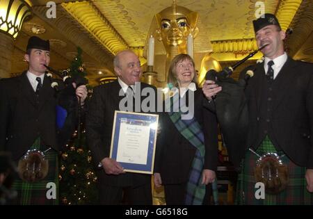 Harrods Chairman Mohamed Al Fayed wird von den Pfeifern Scott McNab, links, und Tony Whelan begleitet, nachdem sie im Ägyptischen Zimmer des Londoner Stores ein Zertifikat über die Freiheit der Highlands von Casia Zajac vom Highlands of Scotland Tourist Board angenommen haben. * Herr Al Fayed, dem Balnagown Estate in Ross-Shire gehört, wurde für seinen Beitrag zur Aufbringung des nördlichen Hochlandes auf die Karte geehrt. Stockfoto