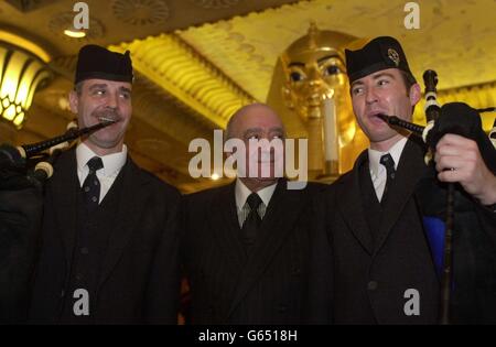 Harrods Chairman Mohamed Al Fayed wird von den Pfeifern Scott McNab, rechts, und Tony Whelan begleitet, nachdem sie im Ägyptischen Zimmer des Londoner Stores ein Zertifikat über die Freiheit der Highlands vom Highlands of Scotland Tourist Board angenommen haben. * Herr Al Fayed, dem Balnagown Estate in Ross-Shire gehört, wurde für seinen Beitrag zur Aufbringung des nördlichen Hochlandes auf die Karte geehrt. Stockfoto