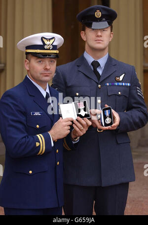 Leutnant William Sasser (links) von der US-Küstenwache hält sein Air Force Cross und steht mit Sergeant Neil Finch von der RAF, der seine Queen's Gallantry Medaille im Buckingham Palace hält. * Sie wurden ihnen von der Königin überreicht, weil sie ihr Leben riskiert hatten, um fünf Besatzungsmitglieder von einem brennenden Frachter im vergangenen Dezember zu retten. Stockfoto