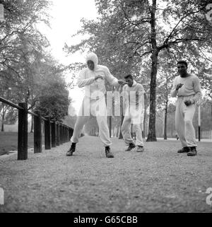 Cassius Clay (links), dessen souveräne Prahlungen er in fünf Runden den britischen Schwergewichtsmeister Henry Cooper schlagen wird, hat alle beim Training auf den Straßen Londons amüsiert. Clay, der Cooper am 18. Juni in Wembley treffen soll, hält sich an eine intensive Routine, die täglich um 5 Uhr beginnt. Stockfoto