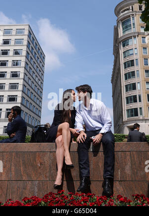 Büroangestellte genießen die Sonne, als die Temperaturen auf 19c in Canary Wharf in London stiegen. Stockfoto