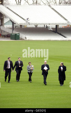 Tim Lamb, Chief Executive der EZB, läuft über das Spielfeld am Lords Cricket Ground, London, flankiert von der Polizei. * die EZB kündigte an, dass das englische Cricket-Team während der bevorstehenden Cricket-Weltmeisterschaft in Simbabwe spielen wird, trotz politischer Bedenken hinsichtlich der Menschenrechtsbilanz von Präsident Mugabe. Stockfoto