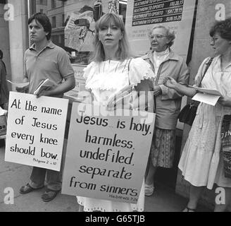 Gavin Childress und Esther Macken mit Plakaten vor dem Plaza Cinema in Piccadilly, London, wo der umstrittene Film "The Last Temptation of Christ" eröffnet wurde. Der Film wurde von einigen religiösen Gruppen bitter angegriffen. Stockfoto