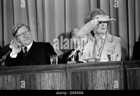 Bundeskanzler Helmut Schmidt nimmt ein Ohr, während Premierministerin Margaret Tahtcher bei einer gemeinsamen Pressekonferenz im Londoner Millbank Tower-Kino, die auf ihr früheres Treffen in der Downing Street Nr. 10 folgte, die Augen verschließt. Stockfoto