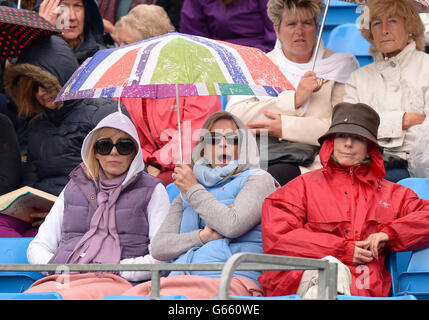 Die Zuschauer schützen sich vor dem Regen, da das Spiel am zweiten Tag der AEGON Championships im Queen's Club, London, unterbrochen wird. Stockfoto