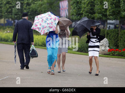 Rennbesucher kämpfen unter windigen Bedingungen während des fünften Tages des Royal Ascot-Treffens auf der Ascot Racecourse, Berkshire. Stockfoto