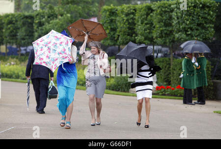 Rennbesucher kämpfen unter windigen Bedingungen während des fünften Tages des Royal Ascot-Treffens auf der Ascot Racecourse, Berkshire. Stockfoto