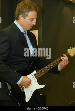 Der britische Premierminister Tony Blair spielt mit Schülern Gitarre bei einem Besuch von Innenminister David Blunkett am Firth Park Community College in Blunketts Wahlkreis Sheffield Brightside. Später besuchten sie eine Computerklasse, in der sie mit Schülern über das Schulleben und die Computerkurse plauderten. Stockfoto