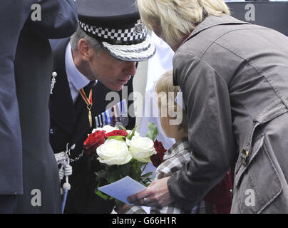 VOM POLIZEIPRESSEBÜRO GERÄUMT der Polizeikommissar Sir Bernard Hogan-Howe spricht mit einer Familie, während sie während einer Zeremonie, in der sie den über 650 Beamten Tribut zollt, die seit der Gründung der MPS im Jahr 1829 im Dienst gestorben sind, auf die Kranzniederlegung wartet. Während der Gedenkzeremonie des Metropolitan Police Service (MPS) im Memorial Garden im Trainingszentrum des Metropolitan Police Peel Center in Hendon, Colindale, London. Stockfoto