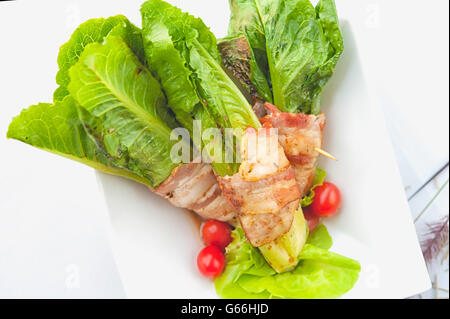 grüne cos eingewickelt in Speck auf weiße Schale Stockfoto