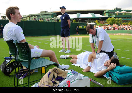 Der britische Colin Fleming wird beim dritten Tag der Wimbledon Championships beim All England Lawn Tennis and Croquet Club in Wimbledon behandelt, als Teamkollege Jonathan Marray (links) im Doppelspiel gegen die Slowaken Martin Klizan und Igor Zelenay zuschaut. DRÜCKEN Sie VERBANDSFOTO. Bilddatum: Mittwoch, 26. Juni 2013. Siehe PA Geschichte TENNIS Wimbledon. Bildnachweis sollte lauten: Adam Davy/PA Wire. EINSCHRÄNKUNGEN: . Keine kommerzielle Nutzung. Keine Videoemulation. Keine Verwendung mit inoffiziellen Logos von Drittanbietern. Stockfoto