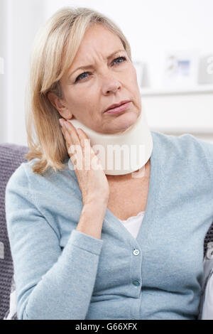 Reife Frau tragen chirurgische Kragen In Schmerzen Stockfoto