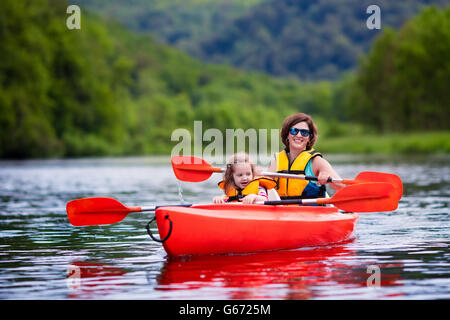 Familie auf Kajak und Kanutour. Mutter und Kind Paddeln im Kajak in einem Fluss an einem sonnigen Tag. Kinder im Sommer-Sport-Camp. Stockfoto