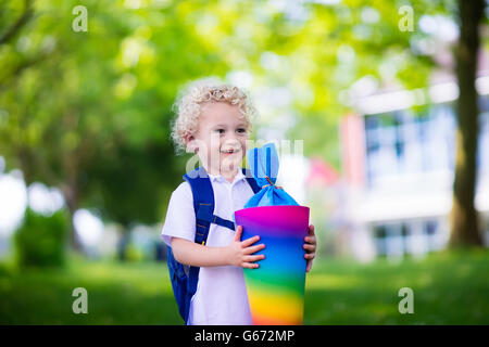 Glückliches Kind mit traditionellen deutschen Süßigkeiten Kegel am ersten Schultag. Kleine Schüler mit Büchern begeistert zurück in der Schule sein. Stockfoto