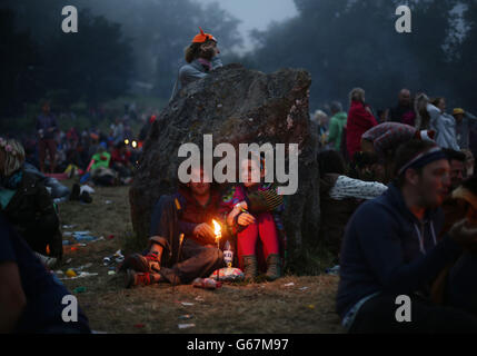 Festivalbesucher im Morgengrauen am Steinkreis, am letzten Tag des Glastonbury Festival of Contemporary Performing Arts 2013 in Worthy Farm, Somerset. Stockfoto