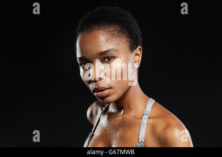 Porträt von eine junge Afro-Amerikanerin in Sportbekleidung auf schwarzem Hintergrund isoliert Stockfoto