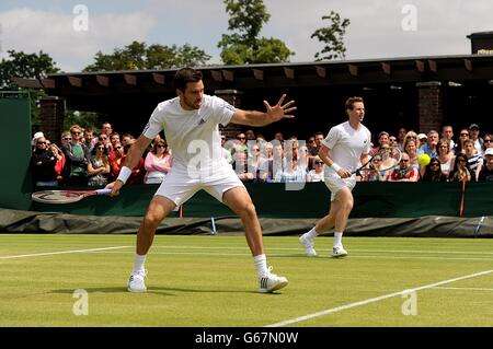 Der britische Colin Fleming (links) mit Partner Jonathan Marray im Spiel gegen den Schweden Robert Lindstedt und den Kanadier Daniel Nestor am siebten Tag der Wimbledon Championships beim All England Lawn Tennis und Croquet Club in Wimbledon. Stockfoto