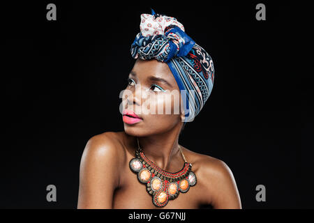 Close-up Portrait einer schönen jungen Afro amerikanische Frau auf der Suche entfernt auf dem schwarzen Hintergrund isoliert Stockfoto