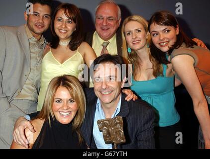 Cast-Mitglieder der Coronation Street, darunter Brian Capron (vorne in der Mitte) mit Roy Hudd (hinten in der Mitte) und ihre Auszeichnung für TV Soap of the Year während der 2003 Television & Radio Industries Club (TRIC) Awards im Grovesnor House Hotel im Zentrum von London. Stockfoto