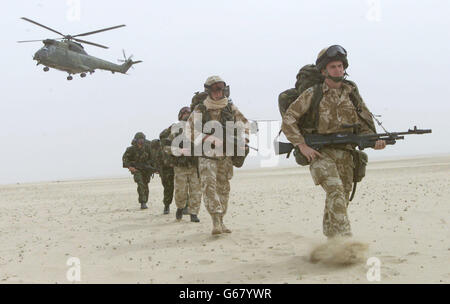 Britische Soldaten des 51. Sqn Royal Air Force Regiment patrouillieren in der Wüste Kuwaiti, während ein Puma-Hubschrauber während einer Praxis Luftangriff Operation entwickelt, um feindlichen Flugplatz zu erobern, außerhalb Kuwait-Stadt. Stockfoto