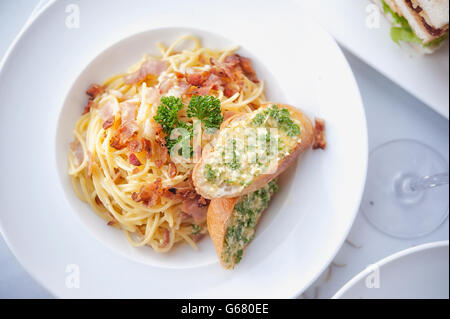 Spaghetti mit Speck und Knoblauch Brot auf weiße Schale Stockfoto