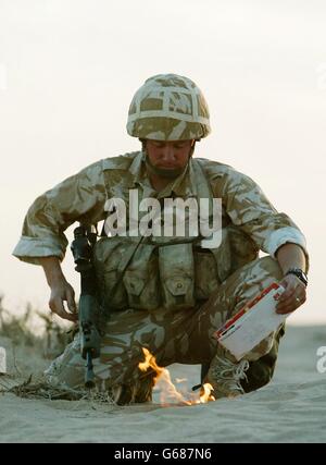 Ein Soldat des britischen 29 Commando Regiment Royal Artillery 'sanitises' sein Kit, indem er seine persönliche Post in der Kuwait-Wüste nahe der irakischen Grenze verbrennt. *..Truppen, die möglicherweise in zukünftige Operationen beteiligt sind, desinfizieren ihre Ausrüstung, um keine Effekte einzuschließen, die für den Feind von Hilfe sein können. Während sich die Militärkräfte am Golf auf den Krieg zurüsten, wird US-Präsident Bush am Sonntag mit den britischen und spanischen Premierministern zusammentreffen, inmitten einer diplomatischen Sackgasse bei den Vereinten Nationen wegen US-geführten Plänen zur Entwaffnung des Irak. Stockfoto