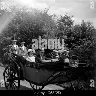 Königin Elizabeth II. Und Prinz Philip, der Herzog von Edinburgh, sind in Sonnenschein gebadet, als sie am zweiten Tag von Royal Ascot am Goldenen Tor ankommen. Stockfoto