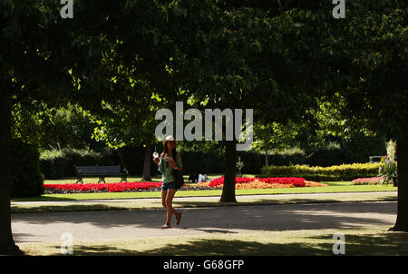 Sommerwetter 15. Juli. Eine Frau, die im Regent's Park im Zentrum von London spazierengeht. Stockfoto