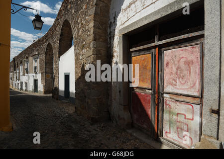 Häuser entlang der Bögen der Roman Aqueduct Silber Wasser in Rua Do Cano Street, Downtown Évora Alentejo, Portugal Stockfoto