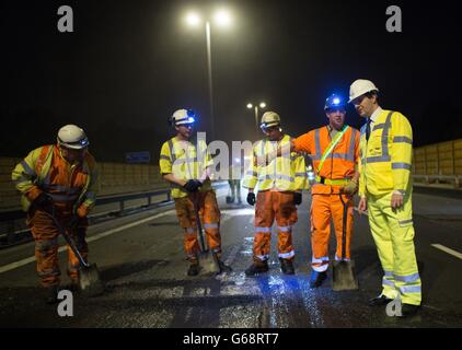 Schatzkanzler George Osborne trifft auf einem Abschnitt der Autobahn M6 in der Nähe von Birmingham auf Arbeitnehmer, wo er sah, wie ein Straßenmanagement-System gebaut wurde, während die Straße geschlossen wurde. Stockfoto