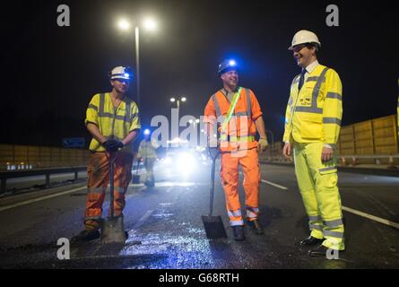 Schatzkanzler George Osborne trifft auf einem Abschnitt der Autobahn M6 in der Nähe von Birmingham auf Arbeitnehmer, wo er sah, wie ein Straßenmanagement-System gebaut wurde, während die Straße geschlossen wurde. Stockfoto