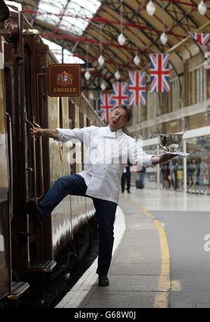 Michelin-Sternekoch Raymond Blanc besucht neben dem britischen Pullman, dem Schwesterzug des Venice Simplon-Orient-Express, eine Fotoserie im Londoner Bahnhof Victoria, um eine Reihe von "Pop-up"-Dinners zu promoten, die von renommierten Köchen im Zug 2013 und 2014 veranstaltet werden. Stockfoto