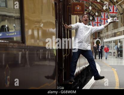 Michelin-Sternekoch Raymond Blanc besucht neben dem britischen Pullman, dem Schwesterzug des Venice Simplon-Orient-Express, eine Fotoserie im Londoner Bahnhof Victoria, um eine Reihe von "Pop-up"-Dinners zu promoten, die von renommierten Köchen im Zug 2013 und 2014 veranstaltet werden. Stockfoto